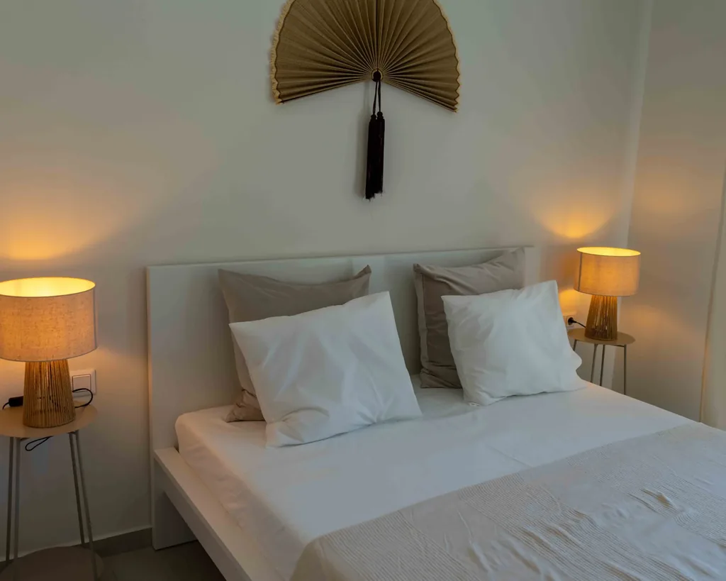 Bedroom of the Orphia apartment with double bed and bedside lamps